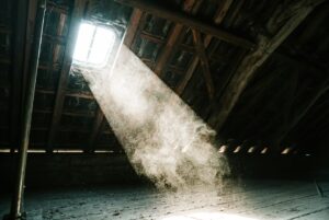 Attic insulation surrounds roof rafters while daylight enters through a properly ventilated eave.